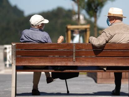 Dos hombres charlan en un banco en San Sebastián.