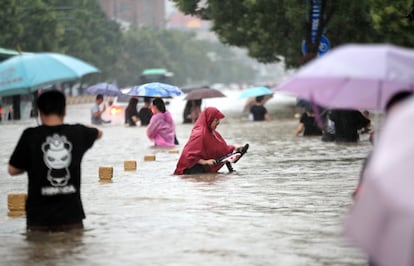 El presidente chino, Xi Jinping, ha exigido en una circular que las autoridades locales den la máxima prioridad a garantizar la seguridad de la población y sus bienes, y que se extremen las medidas de protección contra las inundaciones. En la imagen, varios ciudadanos en una calle de Zhengzhou.