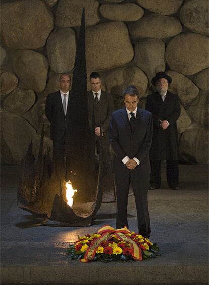 El presidente del Gobierno guarda un minuto de silencio frente a una corona de flores.