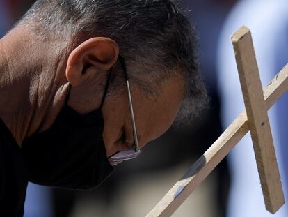 Em Belo Horizonte, manifestante leva uma cruz em protesto pelas mortes pela covid-19 no Brasil.