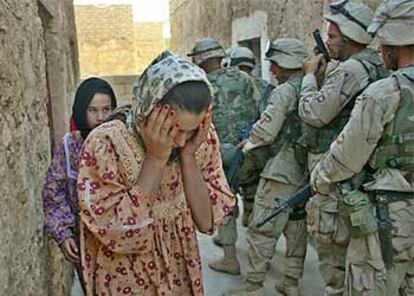 Unas mujeres abandonan su casa en Khaldiyah (este de Bagdad) por orden de los soldados de EE UU para registrala.