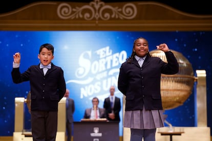 Los niños de la Residencia San Ildefonso de Madrid Axiel Kyron y Ainhoa Rosero muestran el 11840, el tercer premio.