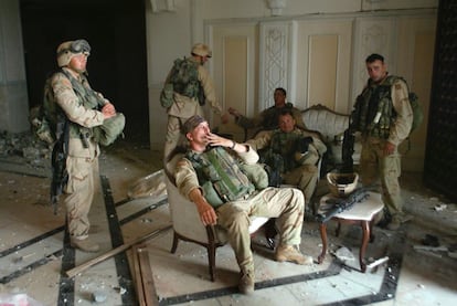 El sargento Chad Touchett, sentado en el centro, toma una calada de su cigarrillo en un salón de uno de los palacios de Sadam Husein en Bagdad.