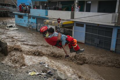 Un rescatista traslada a un niño en medio de una calle inundada en la localidad de Huachipa, cercana a Lima. Ocurrió en el verano del 2017, durante el ‘Niño Costero’.