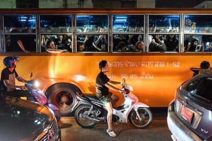 Pasajeros vestidos de negro en un autobús de Bangkok, durante el período oficial de luto.