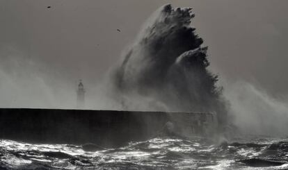 Una ola impacta contra el faro de Newhaven en la costa sur de Inglaterra.