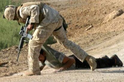 Un <i>marine</i> estadounidense fuerza a un detenido a tumbarse en el suelo en Faluya.