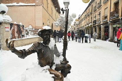 Varias personas pasean por el centro nevado de Alcalá de Henares, este sábado.