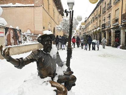Varias personas pasean por el centro nevado de Alcalá de Henares, este sábado.