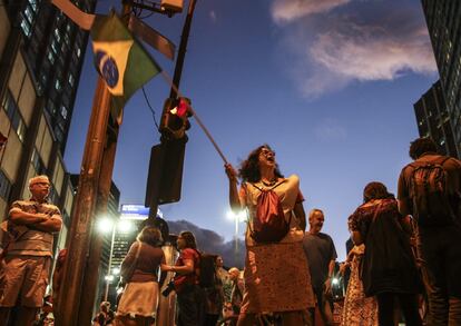 Integrantes dos sindicatos, movimentos sociais e alguns partidos políticos de esquerda participaram nesta quinta-feira de uma marcha pró-democracia e o governo Dilma Rousseff. Na foto, uma militante no Rio de Janeiro com a bandeira do Brasil.