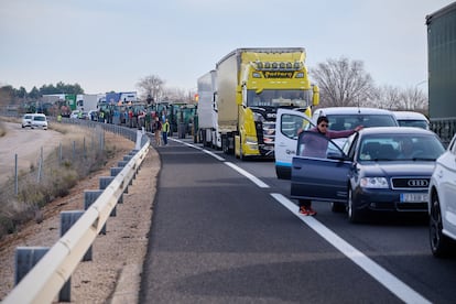 Varios vehículos detenidos por una concentración de tractores que se dirigen hacia el municipio de Manzanares por la autovía A-43, a su paso por la localidad de Tomelloso (Ciudad Real).