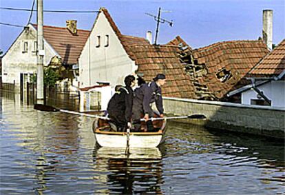 Varios bomberos supervisan los daños provocados por la inundación en la villa Vetrusice, a 30 kilómetros de Praga.