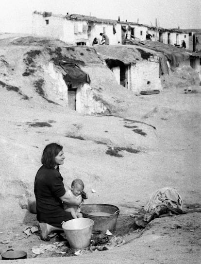 Una mujer baña a su hijo en un balde en un barrio de chabolas a las afueras de Madrid, en 1940.
