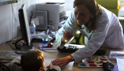 Una doctora examina a un niño en la consulta
