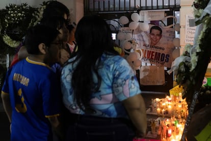 Varias personas visitan el memorial colocado en honor al presidente municipal fuera del Palacio de Gobierno.