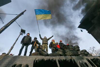 Un manifestante ucranianao agita una bandera nacional en una de las barricadas.  Desde que esta semana aumentó la violencia en las protestas opositoras  en el centro de Kiev, las autoridades reconocen la existencia de dos  víctimas mortales entre los manifestantes, mientras que la oposición  habla de cinco fallecidos.