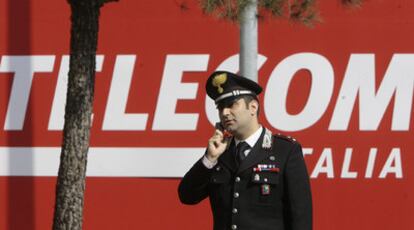 Un policía habla por teléfono delante de un cartel de Telecom Italia en Rozzano.