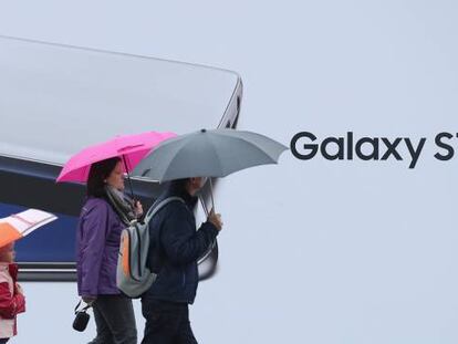 Paseantes frente a un anuncio de Samsung en Berl&iacute;n.