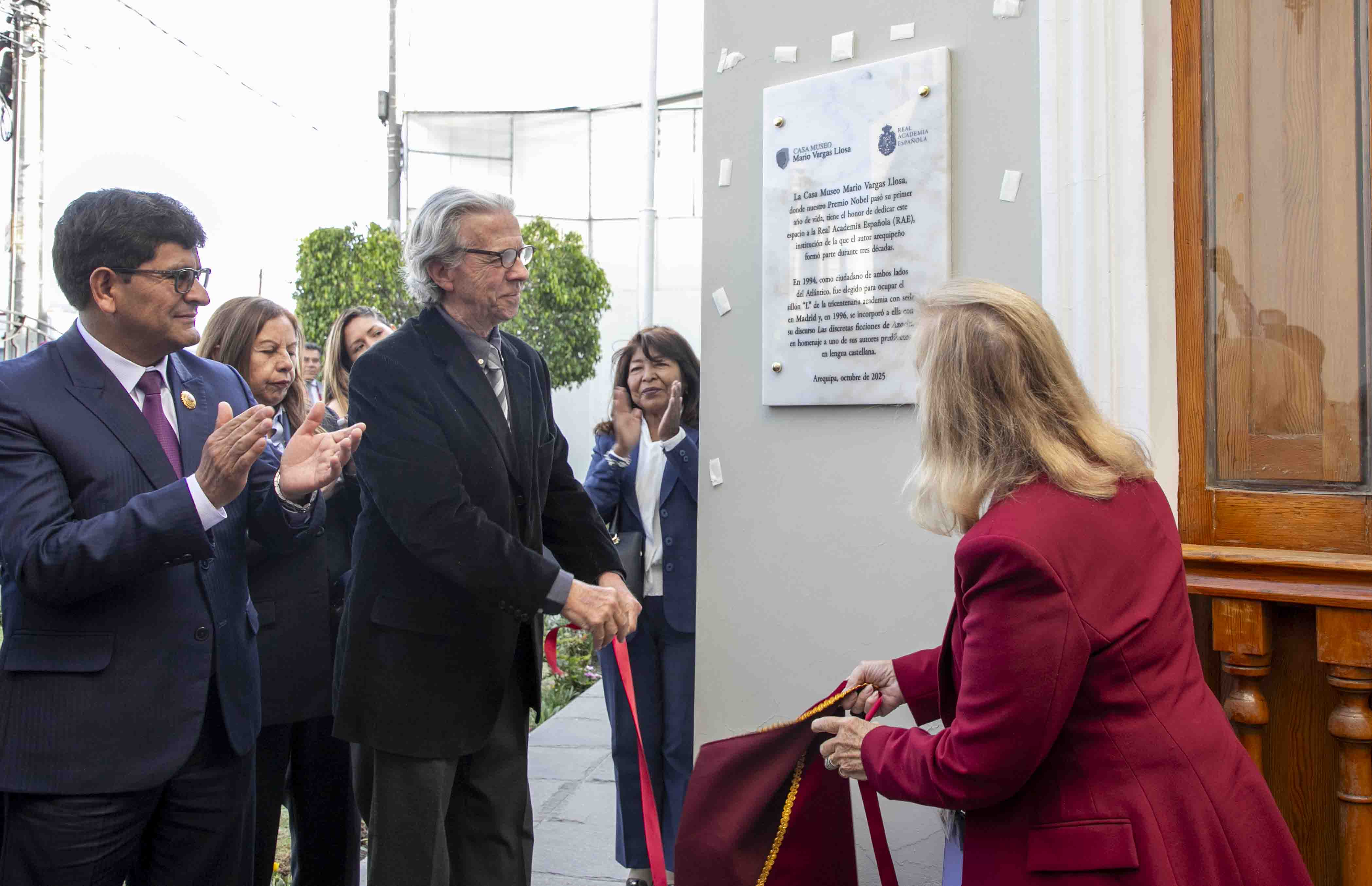 El gobernador de Arequipa, Rohel Sánchez, Luis Llosa, primo del escritor, y Carmen Riera (de espaldas) descubren la placa en homenaje a la RAE en la Casa-Museo Mario Vargas Llosa en Arequipa.