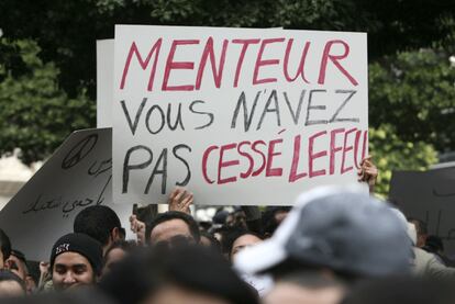 Un ciudadano sostiene una pancarta durante la protesta donde se puede leer "Menteur, vous n'avez pas cessé lefeu" ("Mentiroso, usted no paró el fuego").