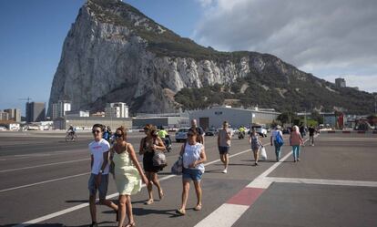 Varios ciudadanos caminan por la pista del aeropuerto de Gibraltar.