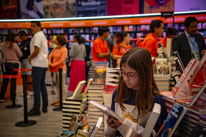 Una niña lee libros en los pasillos de la feria. El fin de semana la FIL estará abierta a todo público.