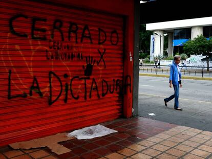 Una mujer pasa junto a un comercio cerrado por la huelga, ayer en Caracas.