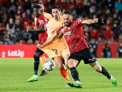 PALMA DE MALLORCA, 09/11/2022.- El delantero albanés del Mallorca, Vedat Muriqi (d), disputa el balón ante el defensa montenegrino del Atlético de Madrid, Stefan Savic, durante el partido Liga en Primera División que disputan hoy miércoles en el estadio de Son Moix, en Palma de Mallorca. EFE/Cati Cladera.
