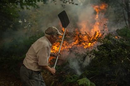 Un vecino de la aldea de Pareisás lucha contra en fuego en el incendio forestal que permanece activo en A Pobra de Trives (Ourense), este miércoles.
