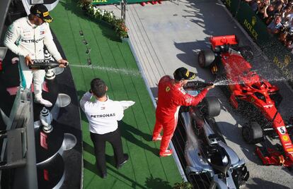 Los pilotos Lewis Hamilton y Sebastian Vettel, segundo en el GP de Hungría, festejan la victoria en el podium del circuito de Hungaroring.