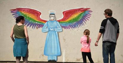 Una familia contempla un mural de la artista Rachel List que rinde homenaje al personal sanitario del Sistema Nacional de Salud británico, en Pontefract, Inglaterra. 