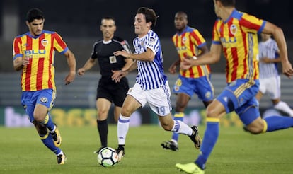 Odriozola rodeado de jugadores del Valencia, en un partido de Liga.