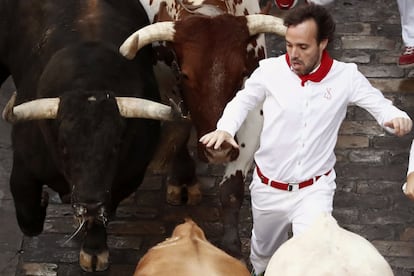 Un mozo corre ante los toros en la calle de la Estafeta.