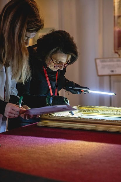 Dos conservadoras examinan una pintura que acaba de regresar al museo tras un préstamo.