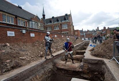 Hombres con disfraces de la Edad Media posan ante el lugar de las excavaciones.
