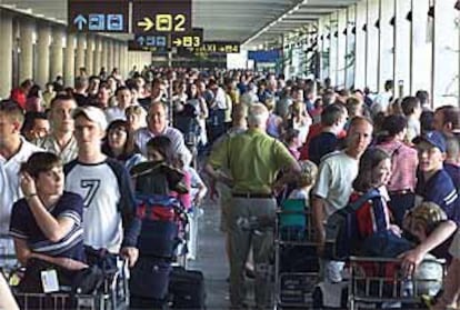Colas de turistas esperan en el aeropuerto de Palma de Mallorca ser trasladados en taxi a sus hoteles.