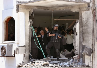 El primer ministro de Palestina, Ismail Haniya (a la izquierda), y el presidente, Mahmud Abbas (segundo por la izquierda), contemplan los daños causados en por los bombardeos israelíes en el despacho oficial de Haniya, en Ciudad de Gaza, el 2 de julio de 2006.