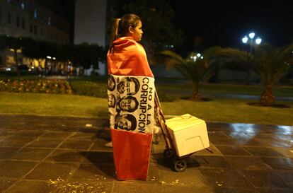 Una manifestante se ha enredado en una bandera, cuyo escudo tiene los rostros de Fujimori y otros políticos, en la que se rechaza a la corrupción.