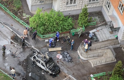 Agentes de la policía rusa e investigadores estudian el lugar donde ha explotado el coche bomba en Moscú este viernes.