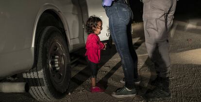 La Yana, d'Hondures, plora mentre la seva mare, Sandra Sánchez, és escorcollada per un policia nord-americà de fronteres a McAllen (Texas).