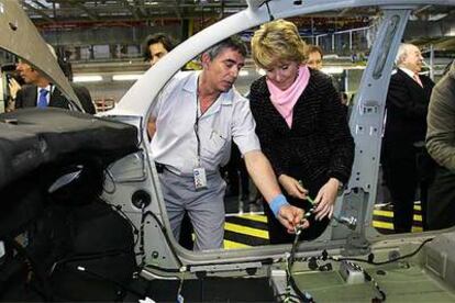 Esperanza Aguirre revisa junto a un trabajador el chasis de un vehículo en la factoría de Peugeot Citroën en Villaverde.