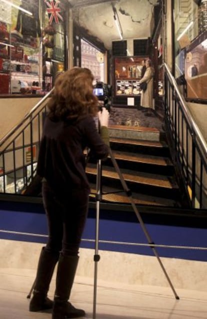 A woman takes a photo of Clive Head&#039;s &#039;Leaving the Underground.&#039;