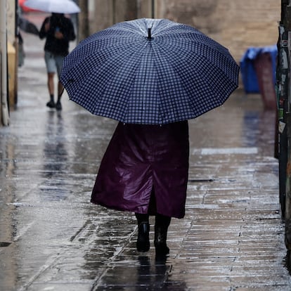 GRAFCVA2988. VALÈNCIA, 19/09/2024.- Una persona camina bajo la lluvia por las calles del centro histórico de València. Diez comunidades continúan este jueves con aviso por lluvias o tormentas, con mayor incidencia en la Comunitat Valenciana, donde persiste la alerta naranja (riesgo importante) por lluvias que acumularán hasta 40 litros en una hora. EFE/Biel Aliño
