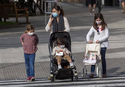 Una madre con tres niños pasea por San Sebastián.