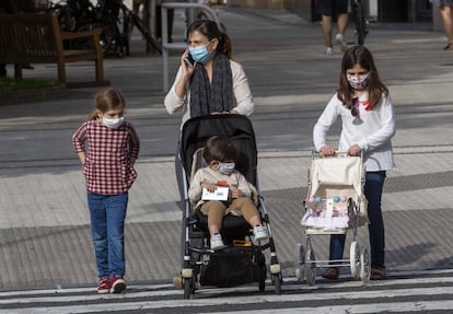 Una madre con tres niños, con mascarilla, pasea por San Sebastián. 
 