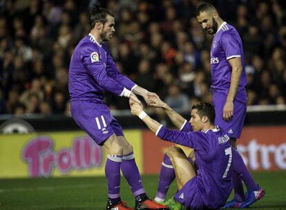 Bale ayuda a Cristiano a levantarse ante la mirada de Benzema en el partido contra el Valencia. 