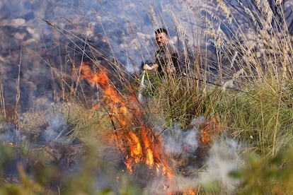 Un voluntario trabaja para apagar las llamas del incendio de Palermo, este miércoles.