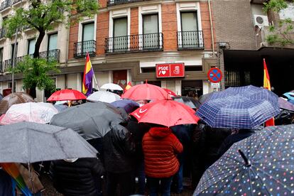 Simpatizantes socialistas se resguardan de la lluvia frente a la sede del partido en Madrid.