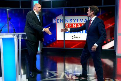 John Fetterman, candidato demócrata al Senado pro Pensilvania (a la izquierda) y Mehmet Oz, su rival republicano en las elecciones, se saludan antes de empezar el debate.