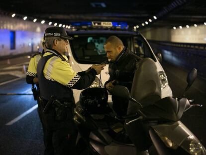 Un agente de la Guardia Urbana de Barcelona hace la prueba de alcoholemia a un motorista, en diciembre pasado. 